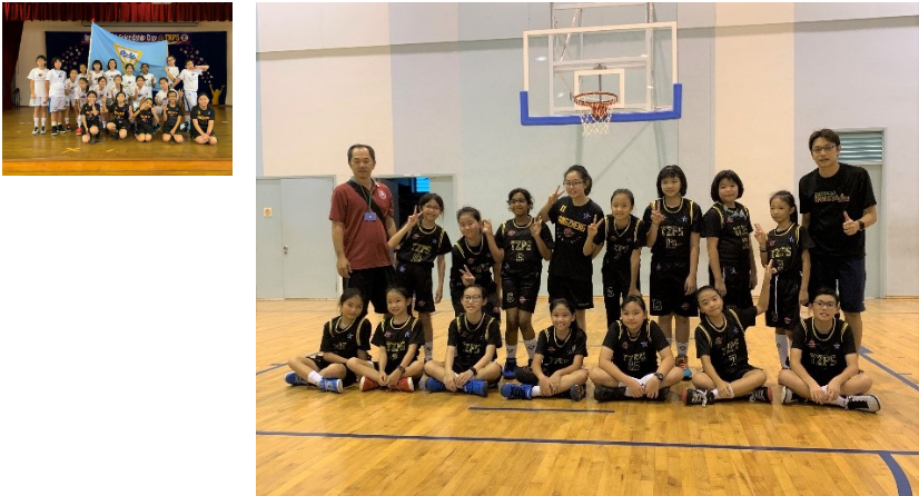 A group of primary school girls basketball players posing at a basketball court with their teachers
